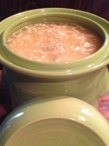 This crock holds 11 pounds of cabbage, pounded with salt until it releases its liquid and collapses. Ceramic weights keep the cabbage submerged as it ferments. 